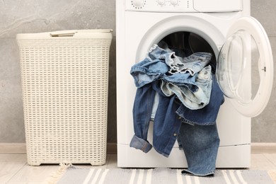 Washing machine with dirty jeans and other denim clothes indoors