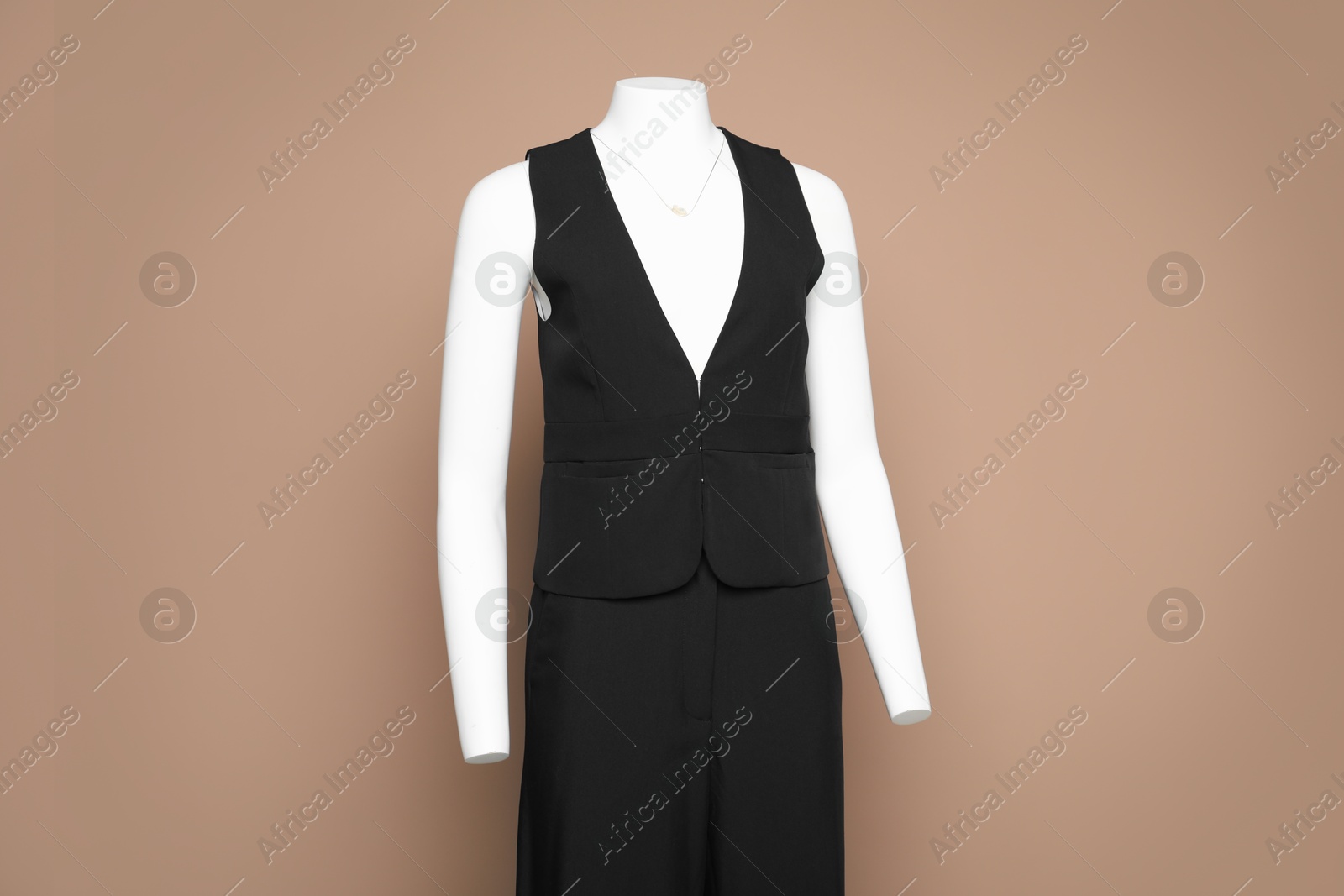 Photo of Female mannequin with stylish black outfit on light brown background