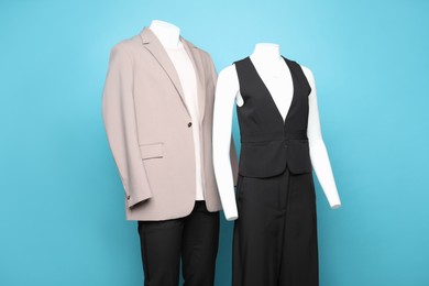 Photo of Female and male mannequins with stylish outfits on light blue background