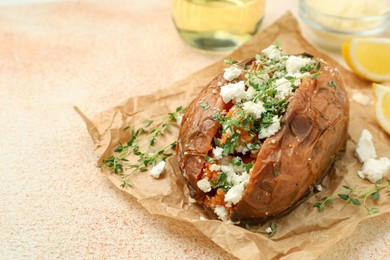 Photo of Tasty baked sweet potato with feta cheese and herbs on light textured table, closeup. Space for text