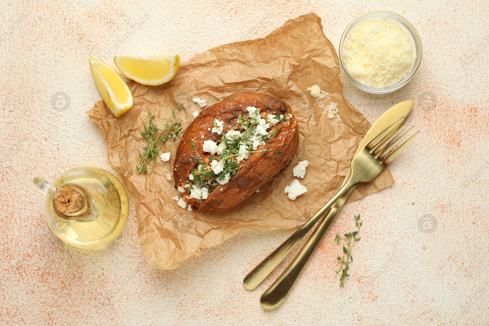 Photo of Tasty baked sweet potato with feta cheese, lemon and herbs on light textured table, flat lay