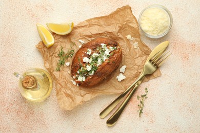 Photo of Tasty baked sweet potato with feta cheese, lemon and herbs on light textured table, flat lay