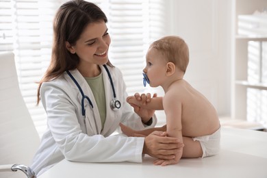 Pediatrician with little child in clinic. Checking baby's health