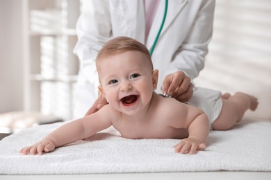 Pediatrician examining little child with stethoscope in clinic, closeup. Checking baby's health