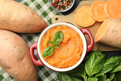 Photo of Tasty mashed sweet potato with basil in, fresh vegetables and spices on table, flat lay