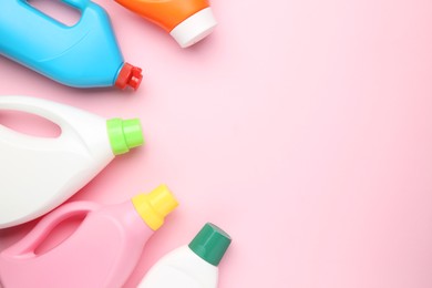 Photo of Bottles of different laundry detergents on pink background, top view. Space for text