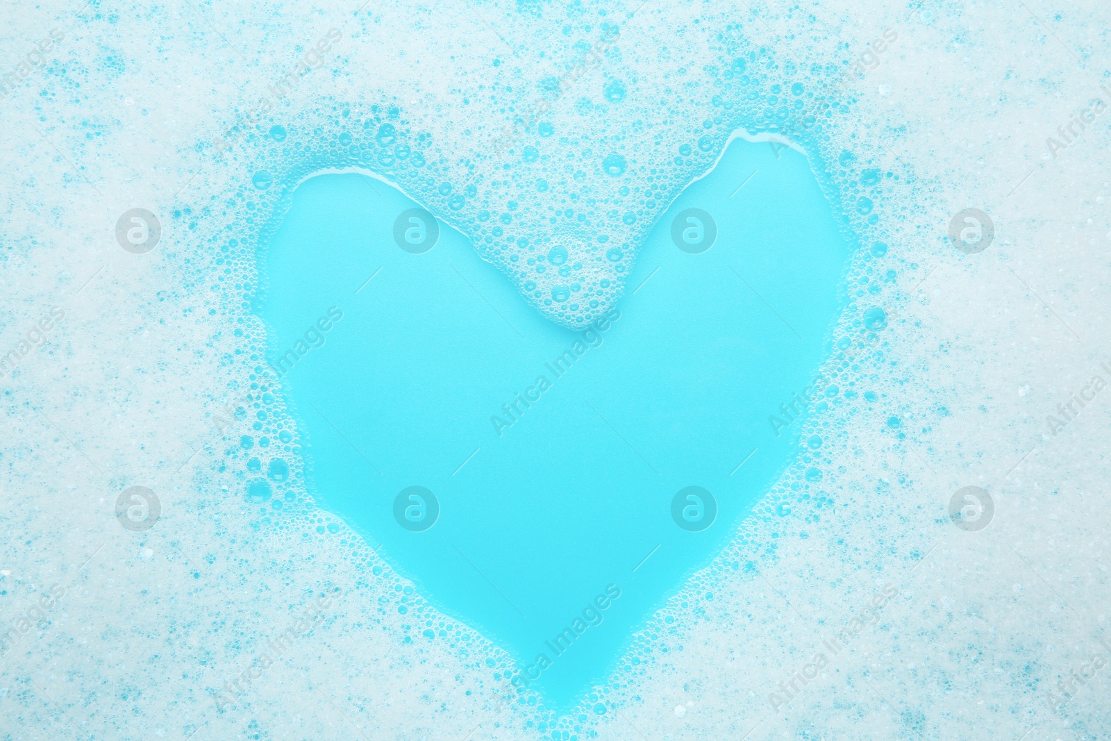 Photo of Washing laundry. White foam with bubbles on light blue background, top view