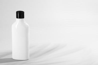 Photo of Bottle of shampoo on light background. Space for text