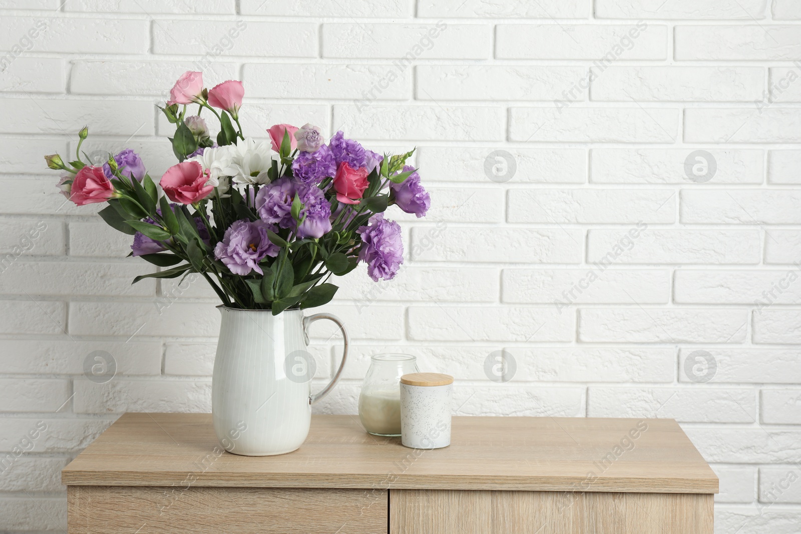 Photo of Vase with beautiful eustoma flowers on wooden chest of drawers, space for text