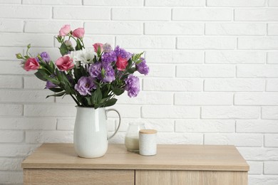 Photo of Vase with beautiful eustoma flowers on wooden chest of drawers, space for text