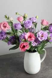 Photo of Vase with beautiful eustoma flowers on grey table