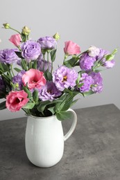 Photo of Vase with beautiful eustoma flowers on grey table