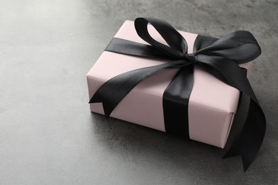 Photo of Gift box with bow on grey table