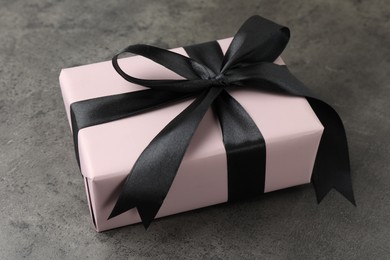 Gift box with bow on grey table