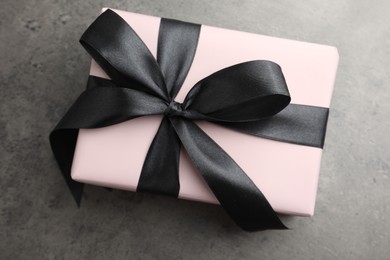 Photo of Gift box with bow on grey table, top view