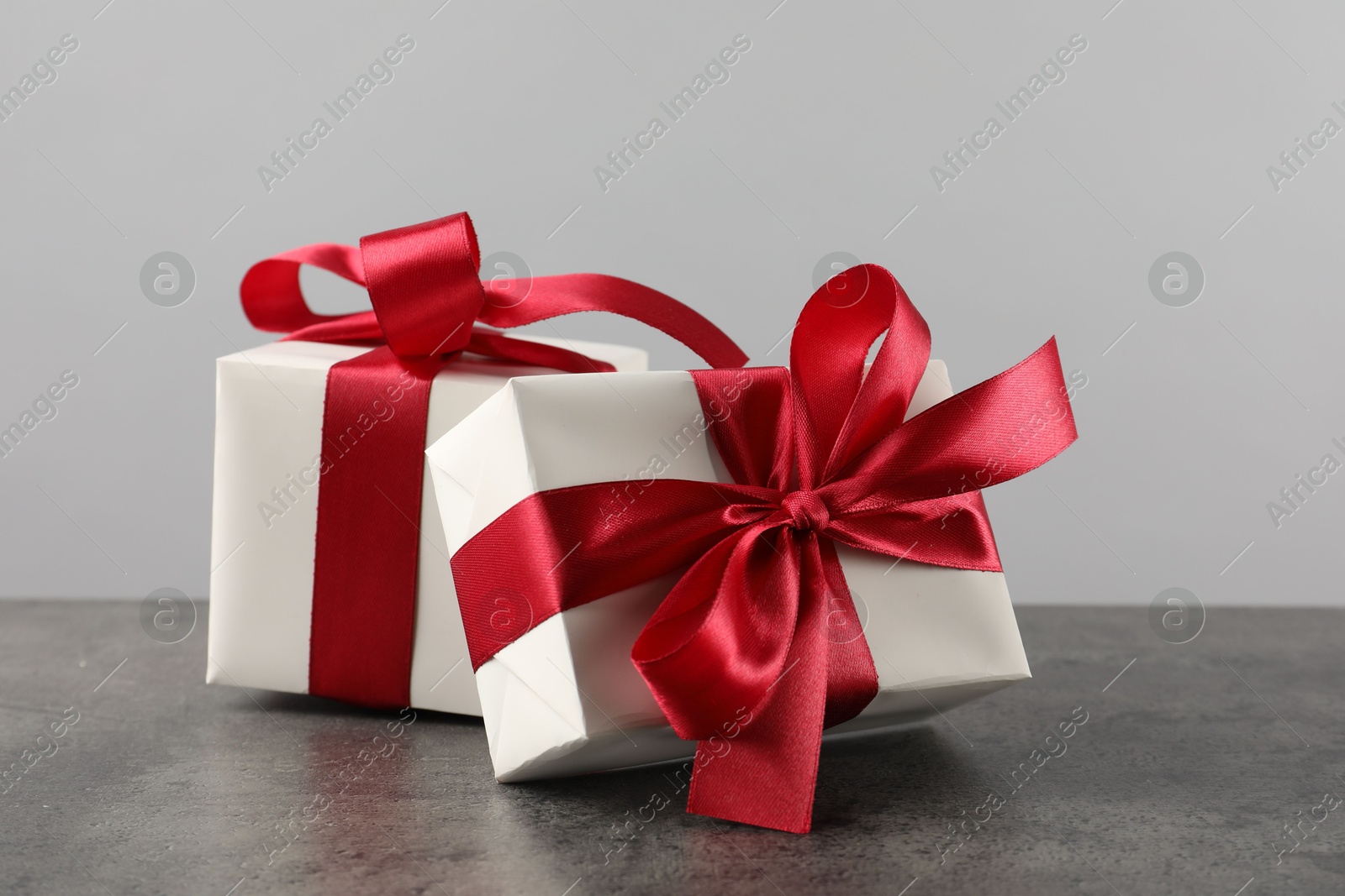 Photo of Gift boxes with bows on grey table