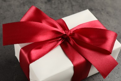 Gift box with bow on grey table, closeup