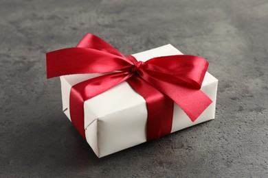 Gift box with bow on grey table