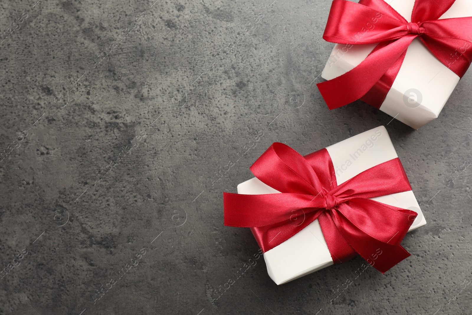 Photo of Gift boxes with bows on grey table, flat lay. Space for text