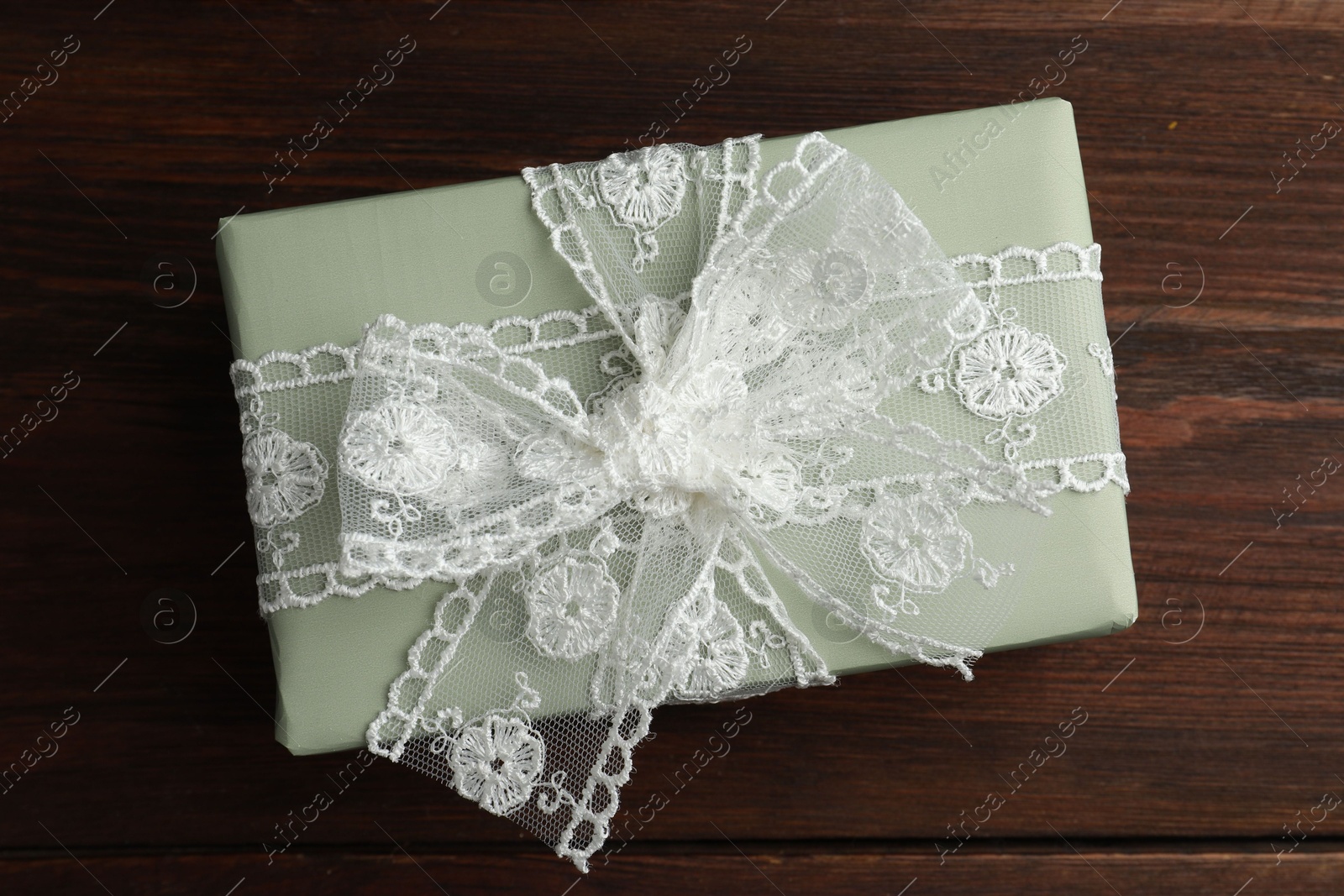 Photo of Gift box with bow on wooden table, top view