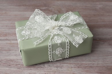 Photo of Gift box with bow on pink wooden table