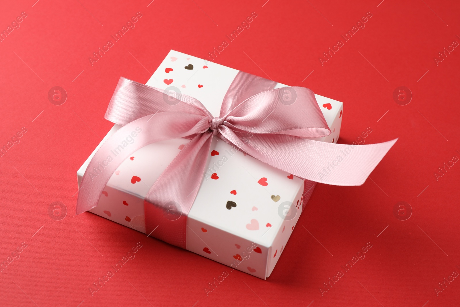 Photo of Gift box with bow on red background