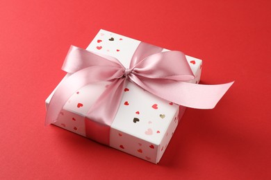 Photo of Gift box with bow on red background