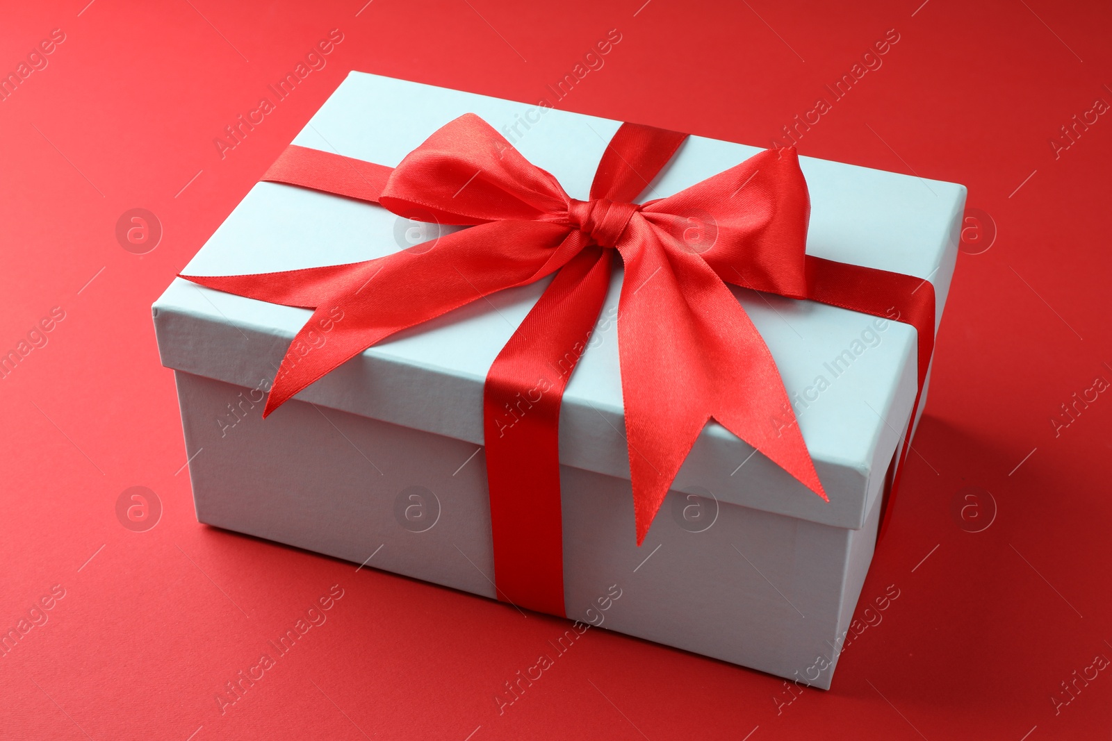 Photo of Gift box with bow on red background