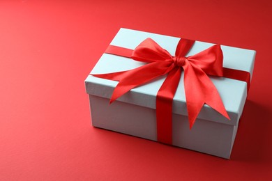 Photo of Gift box with bow on red background