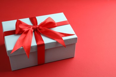 Photo of Gift box with bow on red background