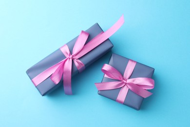 Photo of Gift boxes with bows on light blue background, flat lay