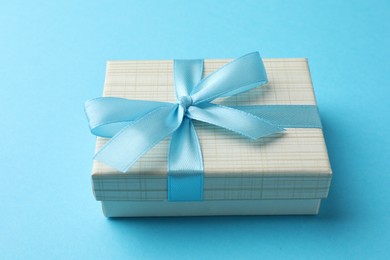 Photo of Gift box with bow on light blue background