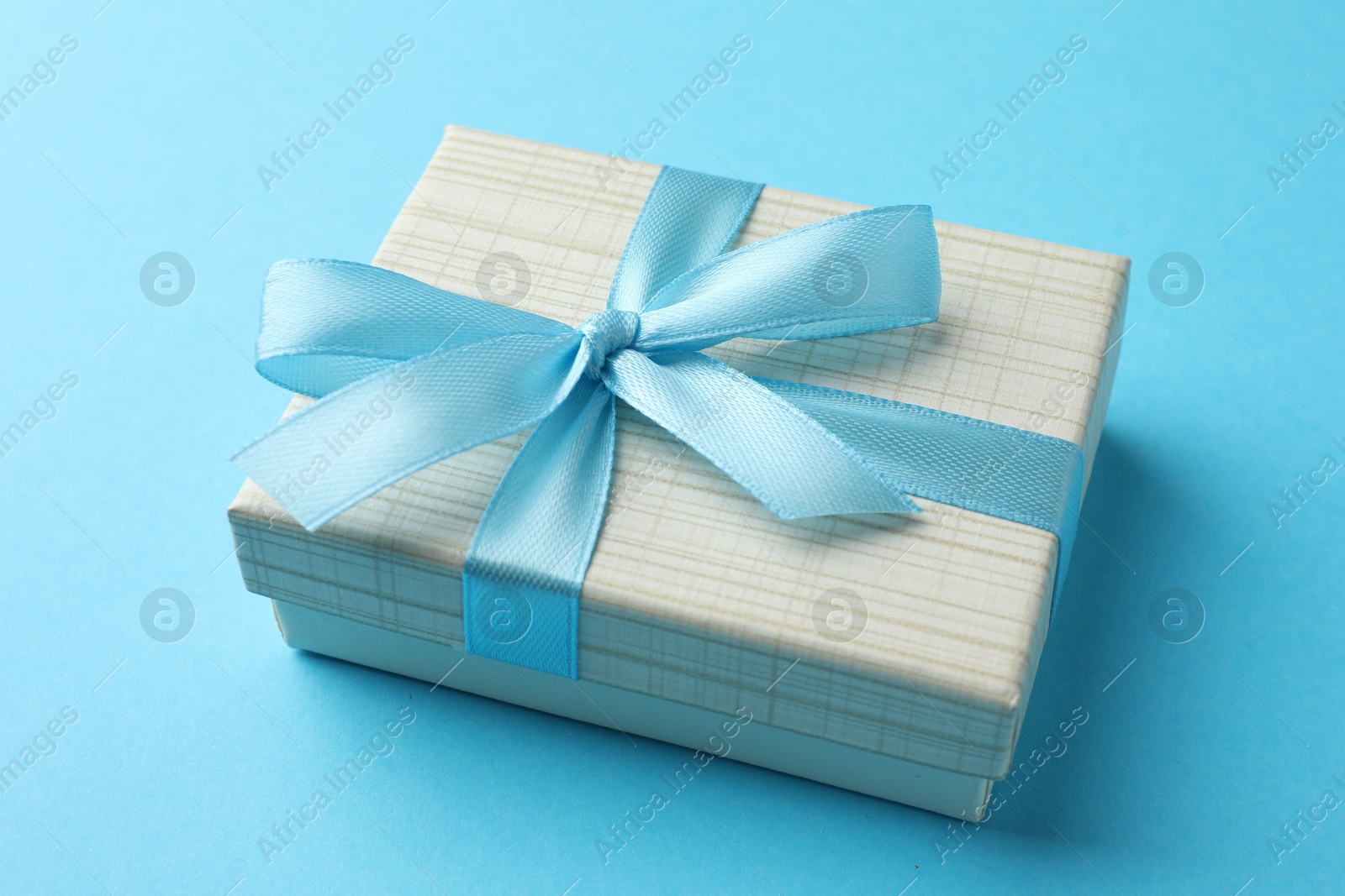 Photo of Gift box with bow on light blue background