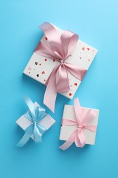 Photo of Gift boxes with bows on light blue background, flat lay