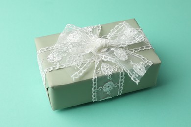 Photo of Gift box with bow on turquoise background