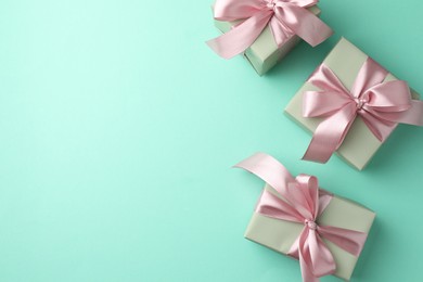 Gift boxes with bows on turquoise background, flat lay. Space for text