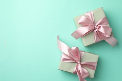 Photo of Gift boxes with bows on turquoise background, flat lay. Space for text