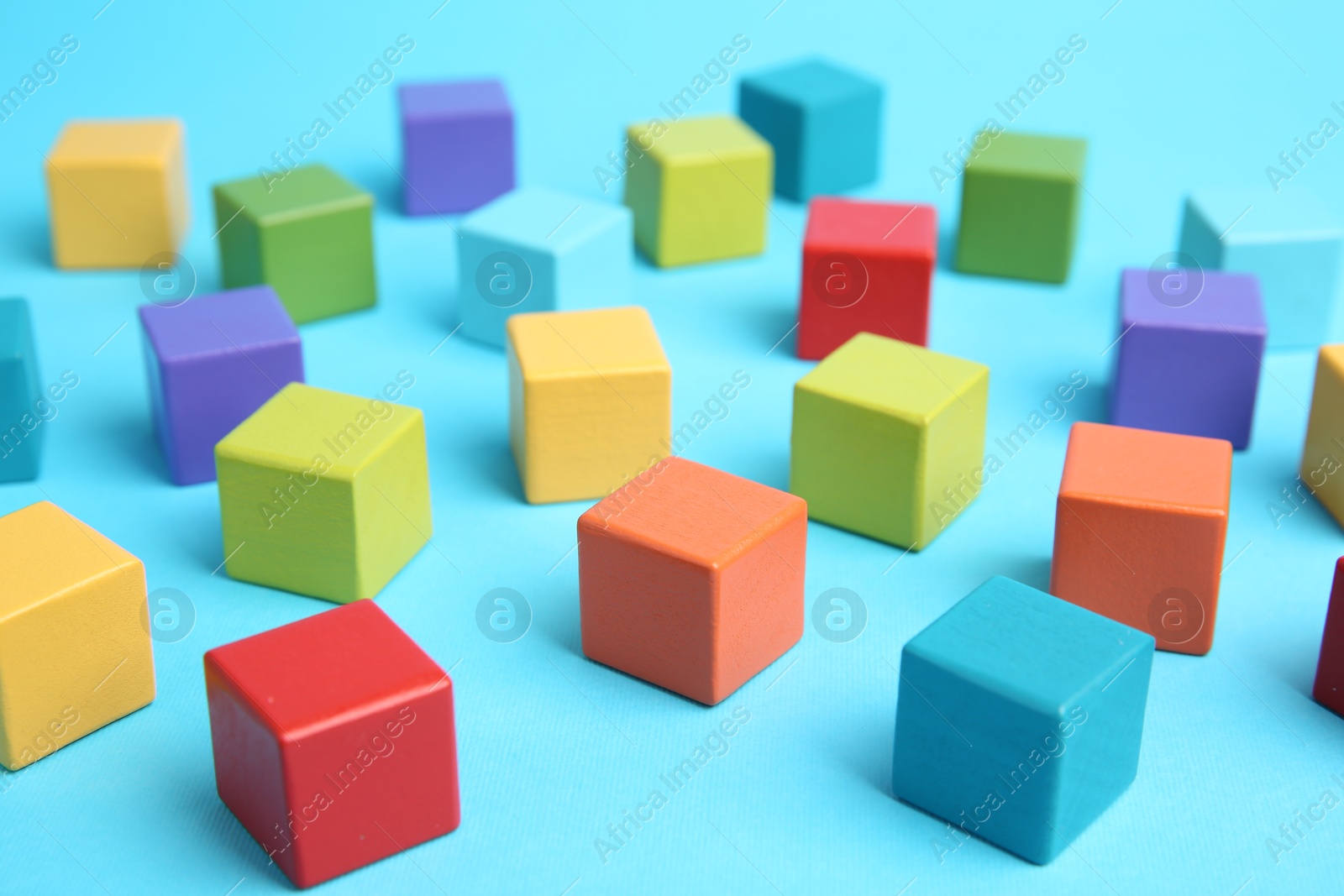 Photo of Many colorful cubes on light blue background