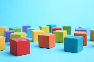 Photo of Many colorful cubes on light blue background