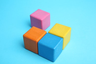 Photo of Many colorful cubes on light blue background