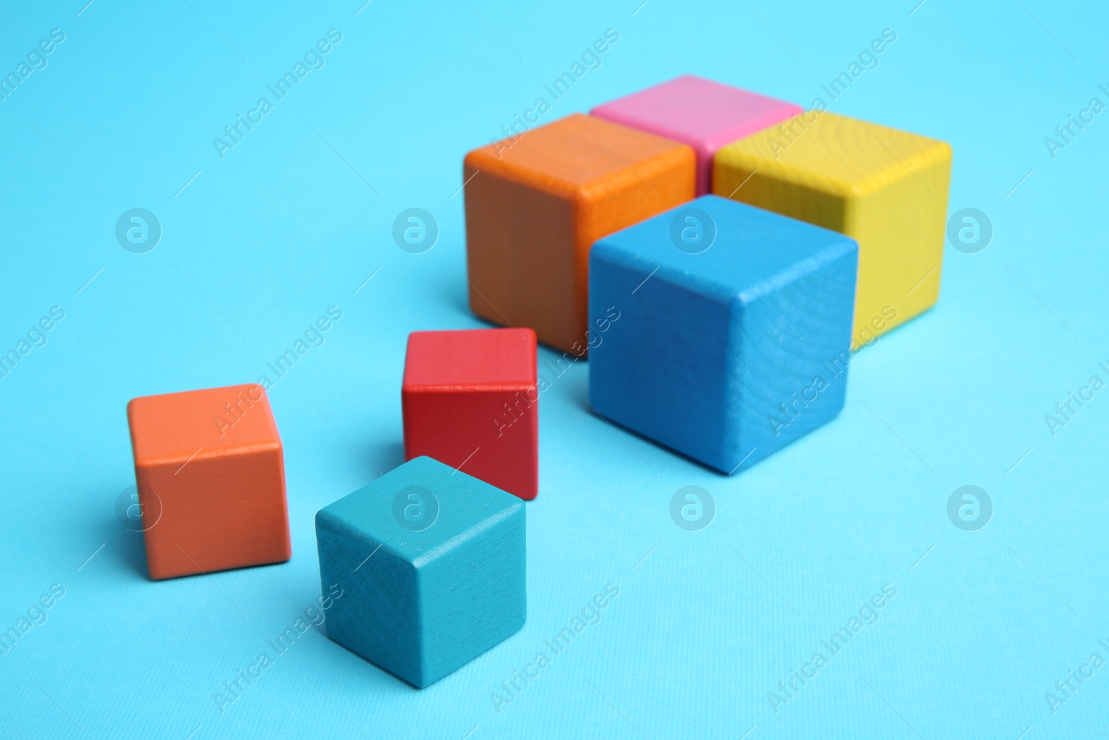 Photo of Many colorful cubes on light blue background