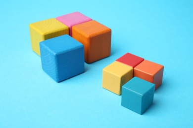 Photo of Many colorful cubes on light blue background