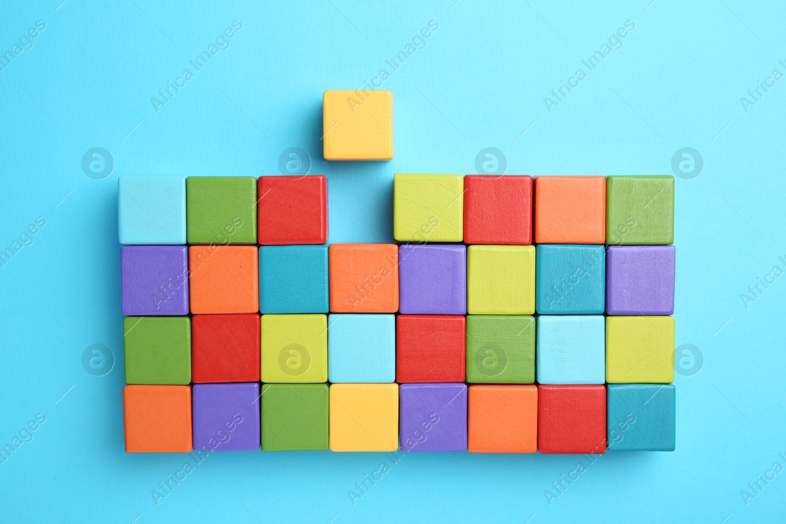 Photo of Many colorful cubes on light blue background, top view