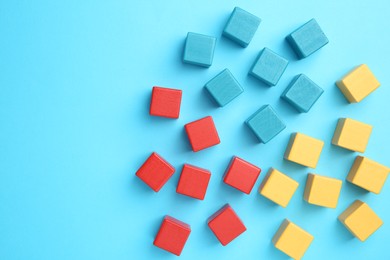 Photo of Many colorful cubes on light blue background, flat lay