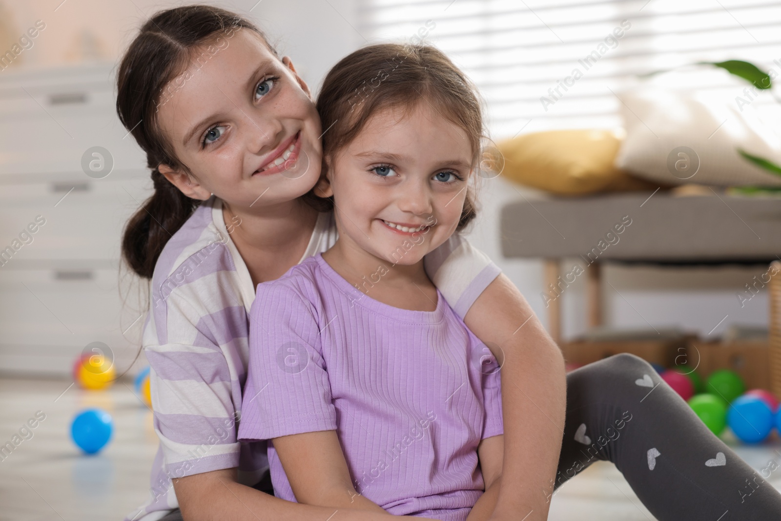 Photo of Portrait of cute little sisters at home