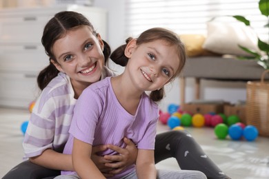 Portrait of cute little sisters at home