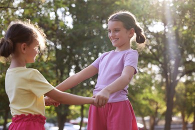 Cute little sisters spending time together in park