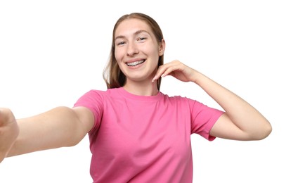 Photo of Smiling girl with braces taking selfie on white background