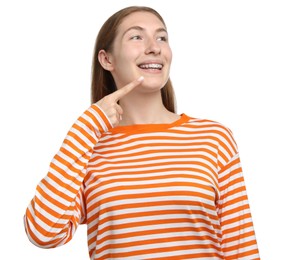 Photo of Smiling girl pointing at her braces on white background