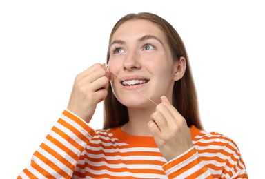 Photo of Smiling girl with braces cleaning teeth with dental floss on white background